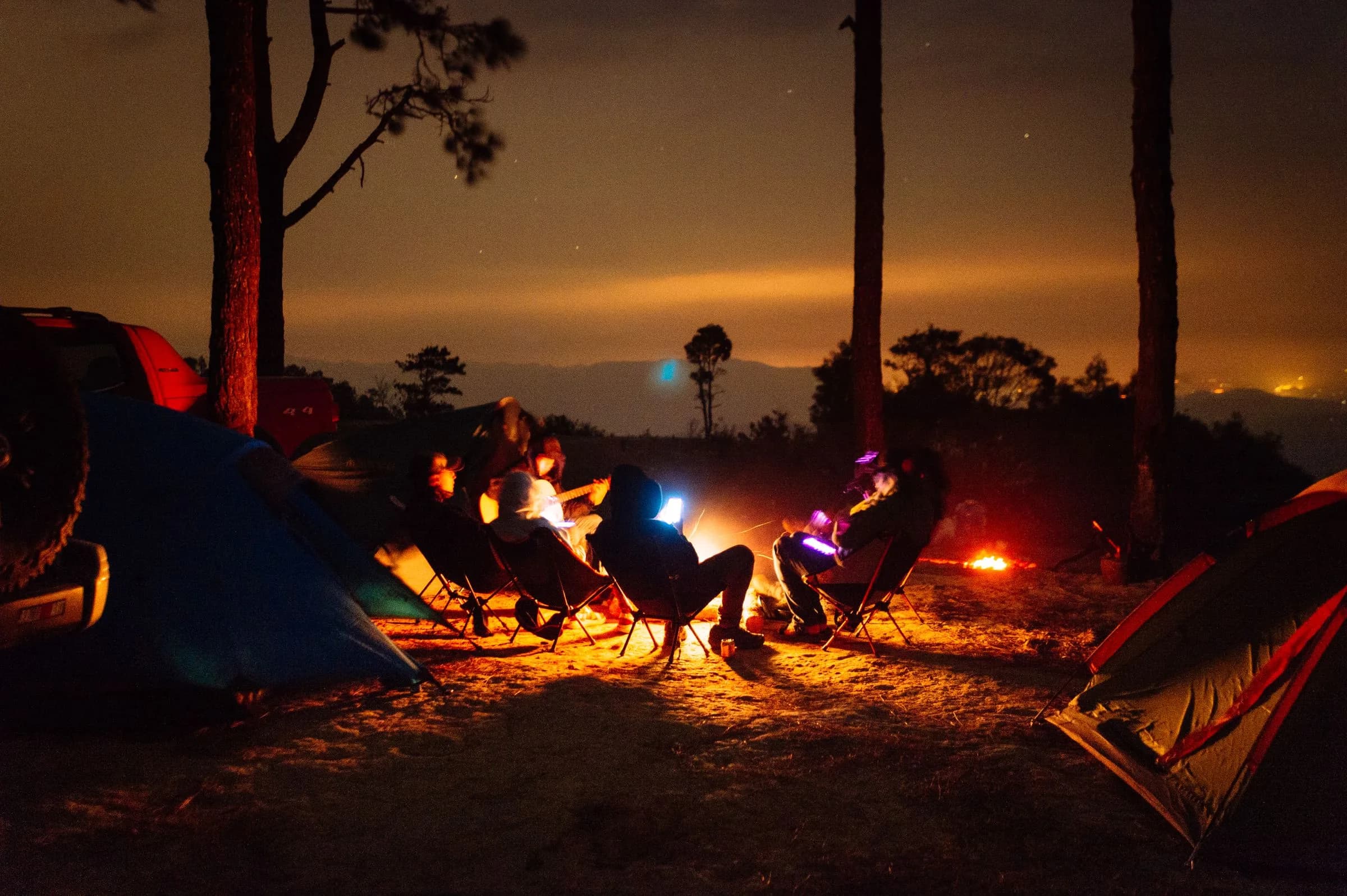 Night campsite with tents and a campfire on a backpacking trip